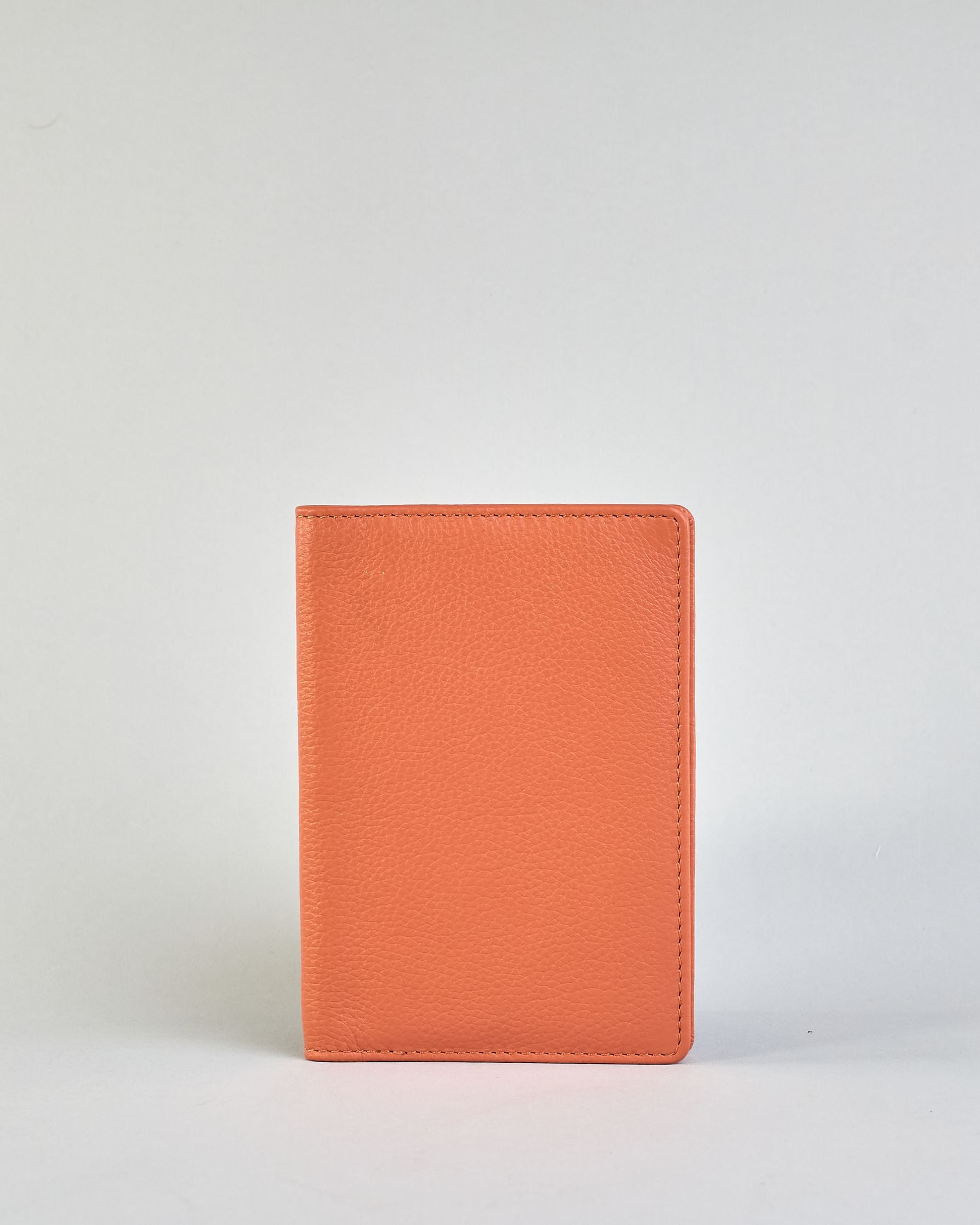 Einfärbige Reisepasshülle aus Leder, innen sind zwei Kartenfächer und ein Schlitz für den Reisepass. Auf der Rückseite ist die Logo Prägung dezent "Herzilein-Wien"