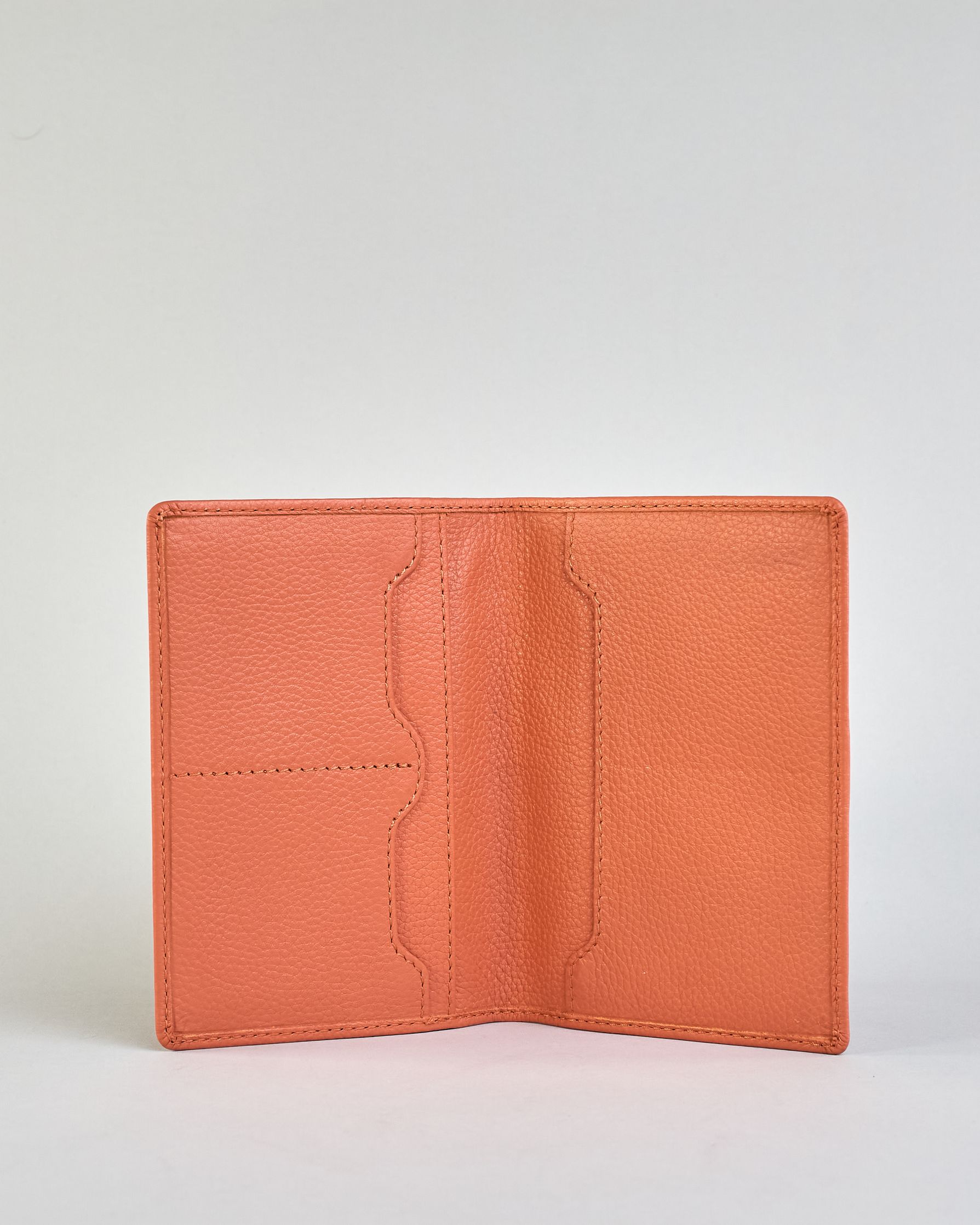 Einfärbige Reisepasshülle aus Leder, innen sind zwei Kartenfächer und ein Schlitz für den Reisepass. Auf der Rückseite ist die Logo Prägung dezent "Herzilein-Wien"