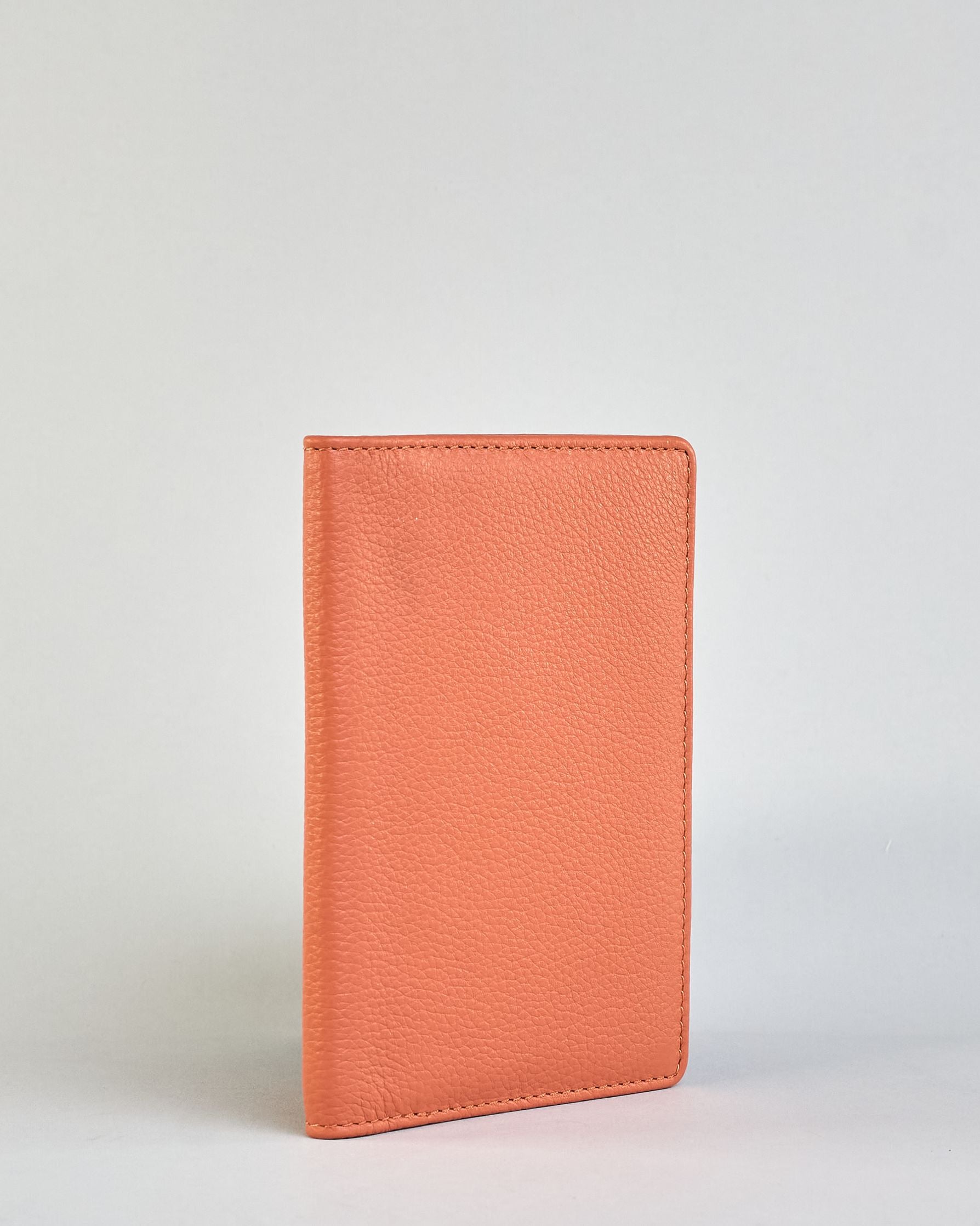 Einfärbige Reisepasshülle aus Leder, innen sind zwei Kartenfächer und ein Schlitz für den Reisepass. Auf der Rückseite ist die Logo Prägung dezent "Herzilein-Wien"