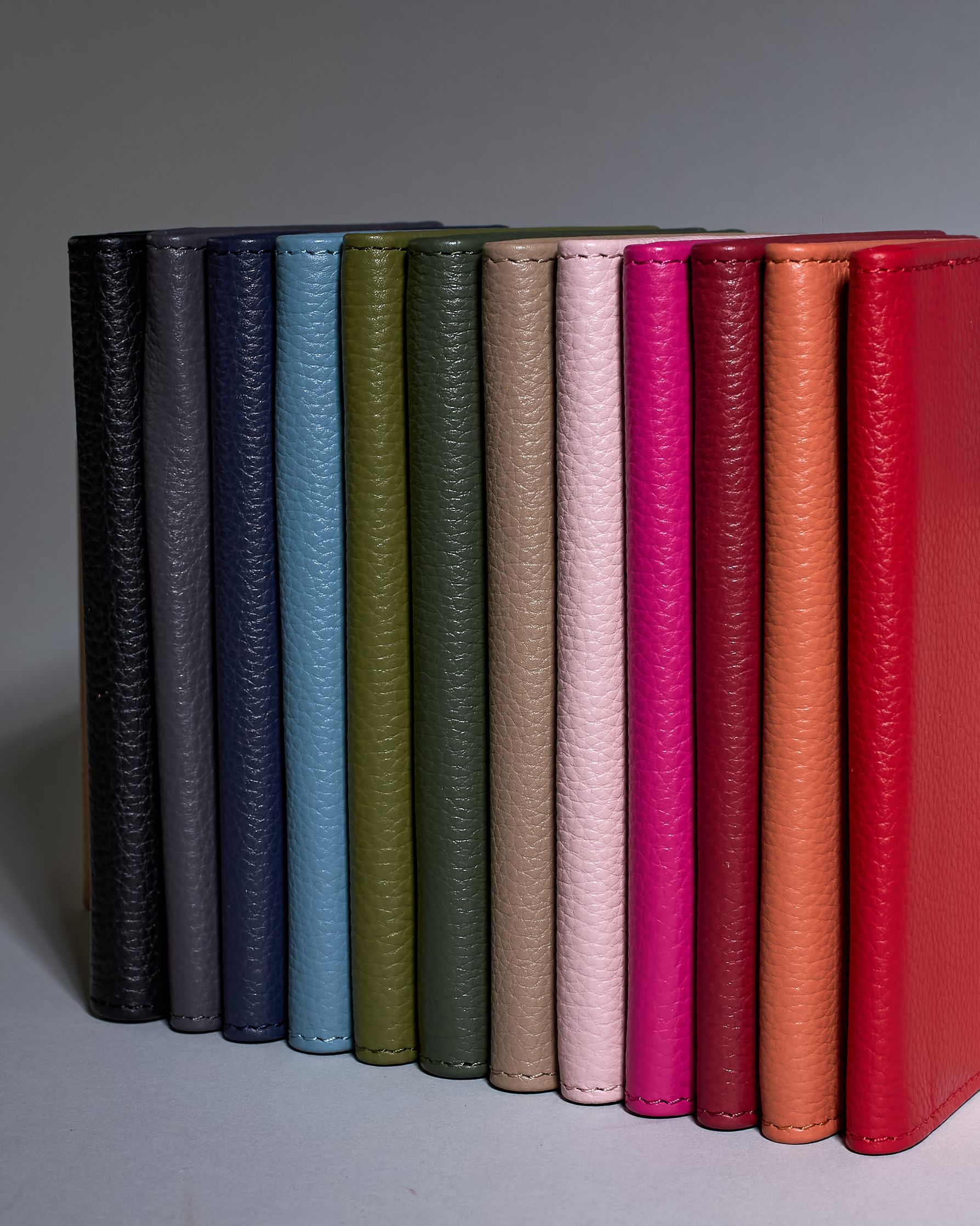 Einfärbige Reisepasshülle aus Leder, innen sind zwei Kartenfächer und ein Schlitz für den Reisepass. Auf der Rückseite ist die Logo Prägung dezent "Herzilein-Wien"