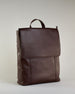 Brauner Rucksack aus Rindleder mit großer Überschlagklappe, verstellbaren Schulterriemen und mehreren Innen- und Außenfächern. Er ist simpel gestaltet und hat nur ein kleines Logo "Herzilein-Wien" unter der Lasche. #4