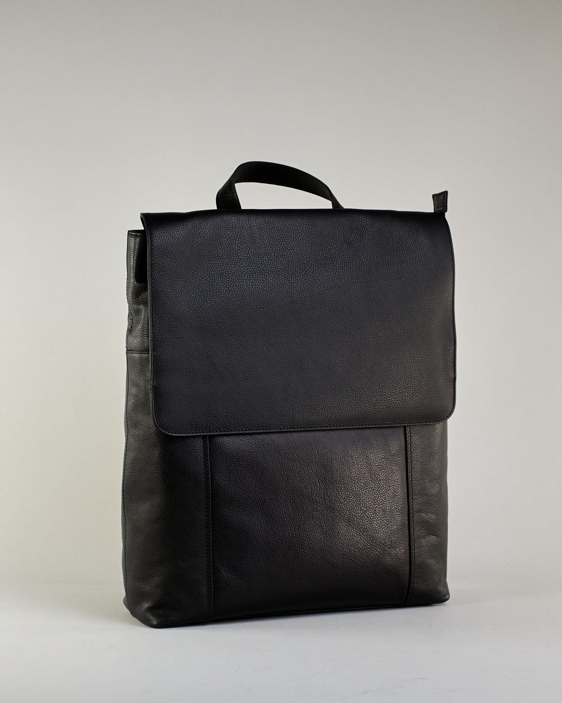 Schwarzer Rucksack aus Rindleder mit großer Überschlagklappe, verstellbaren Schulterriemen und mehreren Innen- und Außenfächern. Er ist simpel gestaltet und hat nur ein kleines Logo "Herzilein-Wien" unter der Lasche. #2