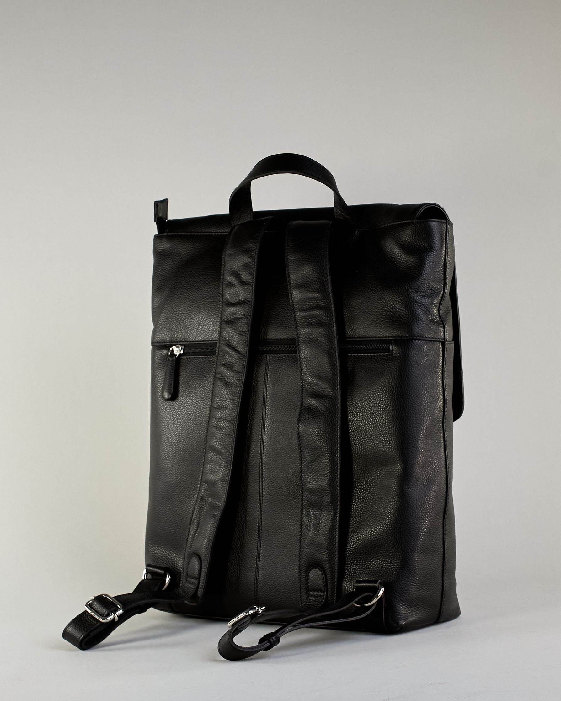 Schwarzer Rucksack aus Rindleder mit großer Überschlagklappe, verstellbaren Schulterriemen und mehreren Innen- und Außenfächern. Er ist simpel gestaltet und hat nur ein kleines Logo "Herzilein-Wien" unter der Lasche. #3