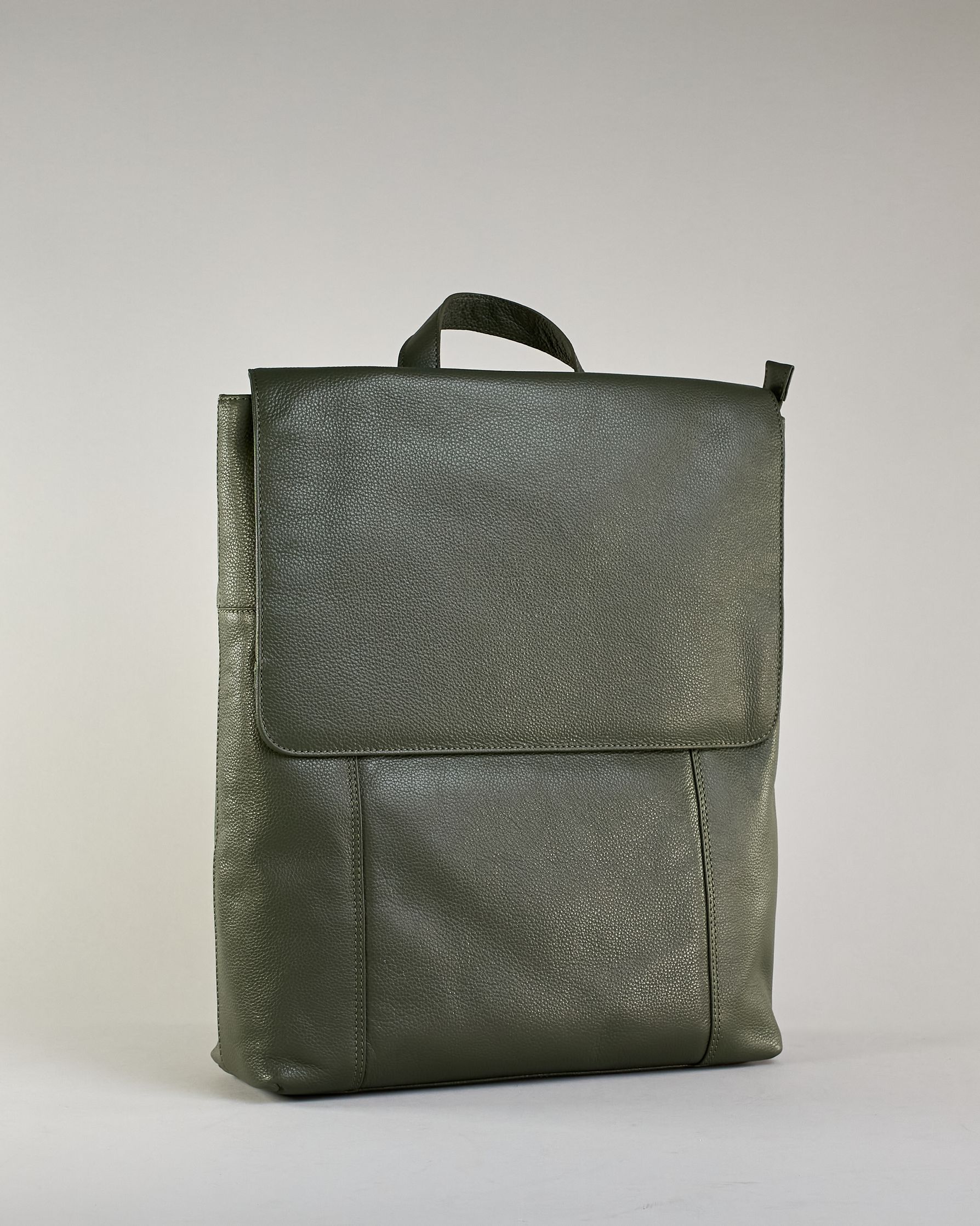 Dunkelgrüner Rucksack aus Rindleder mit großer Überschlagklappe, verstellbaren Schulterriemen und mehreren Innen- und Außenfächern. Er ist simpel gestaltet und hat nur ein kleines Logo "Herzilein-Wien" unter der Lasche. #2